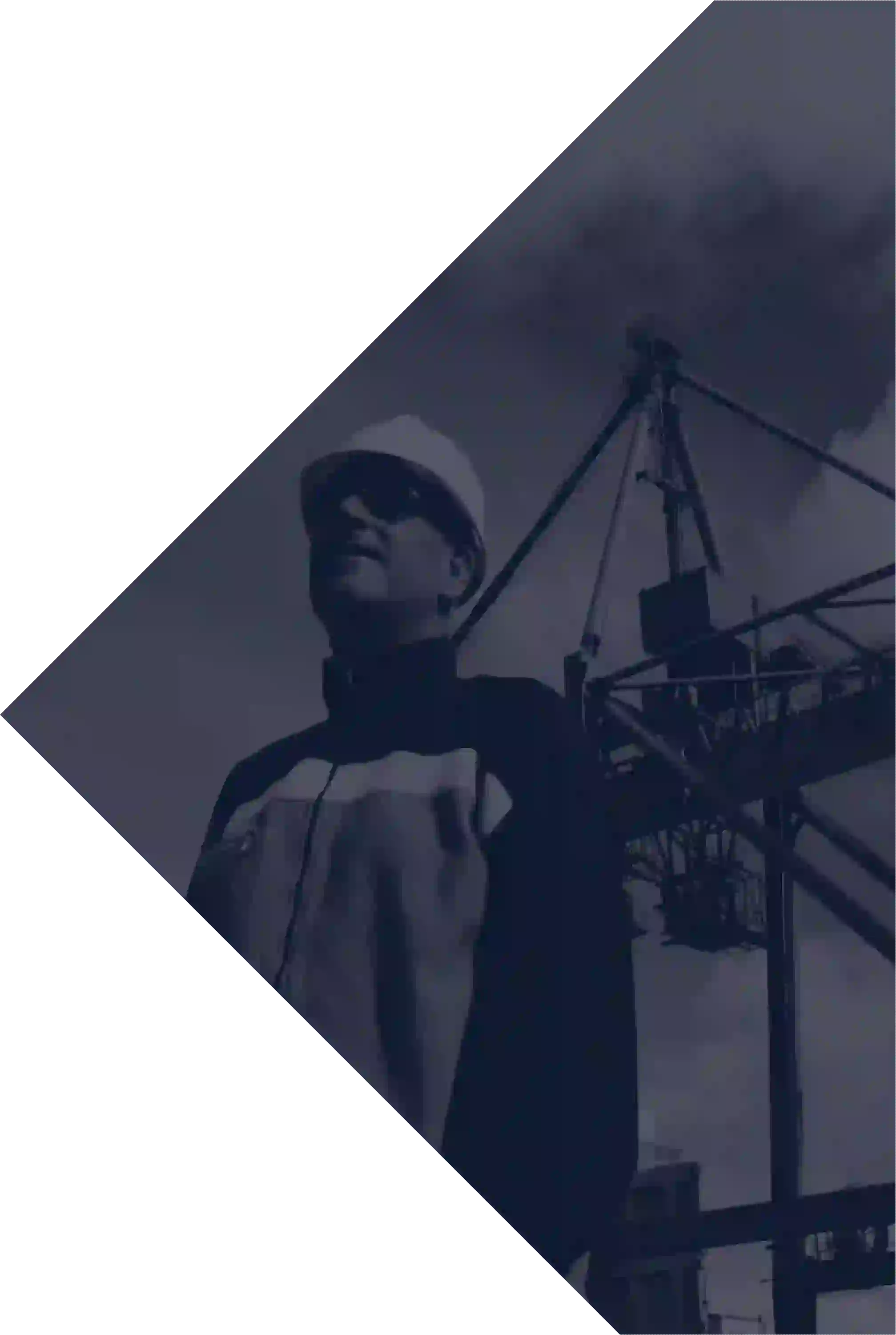 man looking forward next to a crane at a wharf